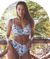 Women modelling floral pattern swimwear against a tropical looking backdrop